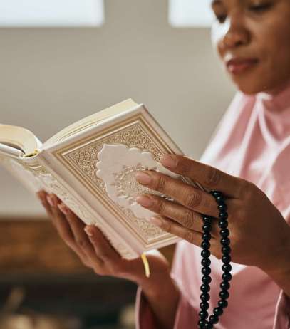 Close-up of Muslim woman reading the holy book Quran in a mosque.